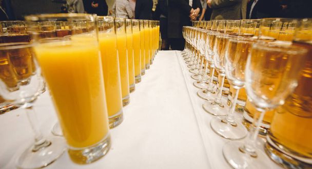 Una gran cantidad de copas de champán blanco y jugo en una lujosa vista de la atmósfera desde arriba. ejemplo de la foto para el año nuevo, boda. vasos dispuestos alineados en una larga fila. Foto entre gafas
 - Foto, imagen