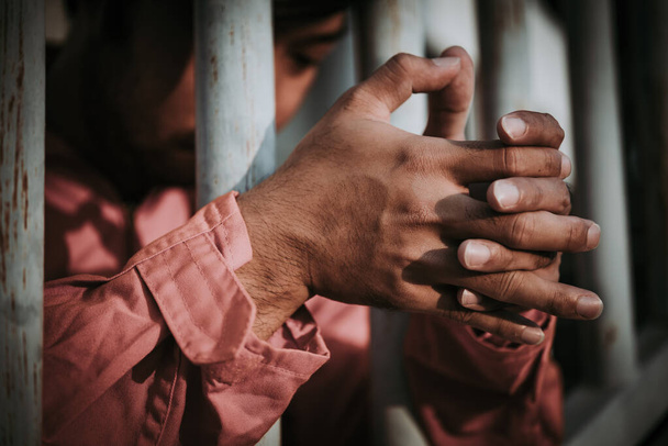 Ręce ludzi desperacko próbujących złapać żelazne więzienie, koncepcję więźnia, ludzi z Tajlandii, nadzieję na wolność, winnego karze się. - Zdjęcie, obraz
