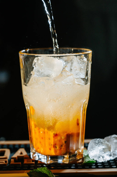 hand bartender make cocktail. Cocktail have orange and mint leaves. - Zdjęcie, obraz