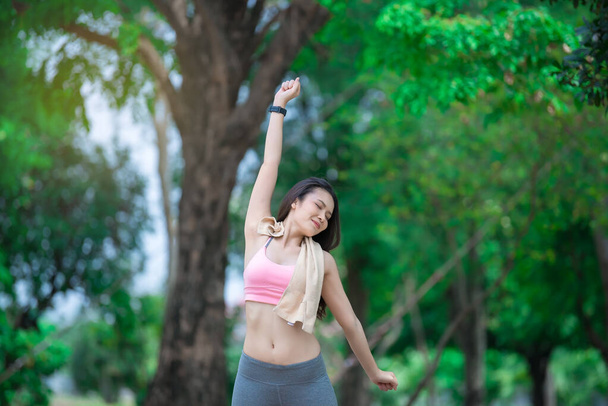 Aasialainen urheilullinen nainen venyttely kädet hengittää raitista ilmaa puistossa, Thaimaa ihmiset käyttävät käsite
 - Valokuva, kuva