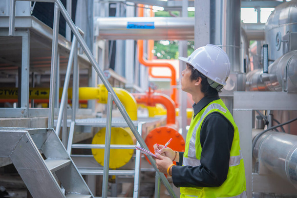 Asian Maintenance engineer at the waste water management system of a huge factory,maintenance checking technical data of heating system equipment,Thailand people - Valokuva, kuva