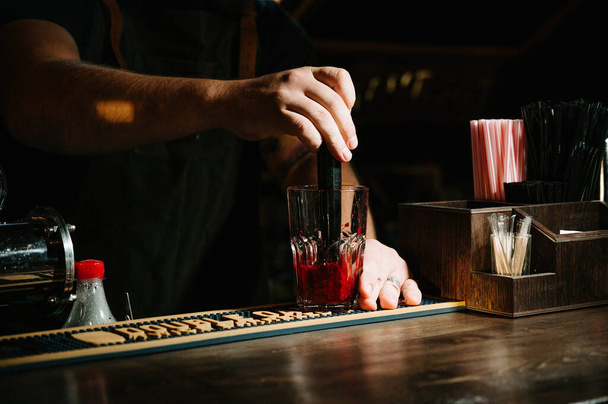 Hand Barkeeper machen Cocktail. Cocktail mit Kirsch- und Minzblättern. - Foto, Bild