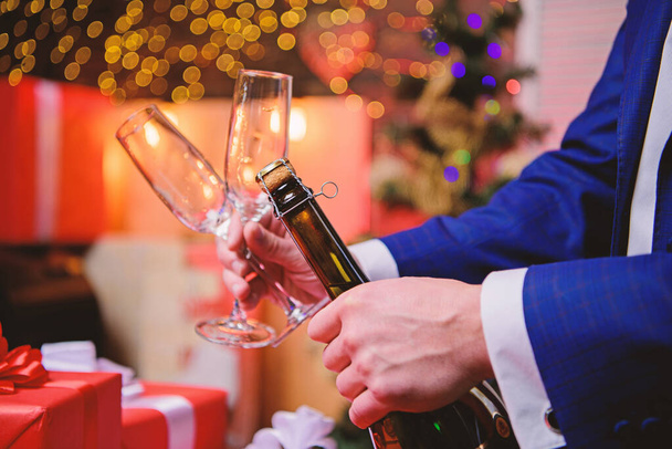 Open champagne and celebrate holiday. Celebrate new year with champagne drink. Toast and cheers concept. Lets celebrate. Male hands opening champagne bottle on christmas decorations background - Photo, Image