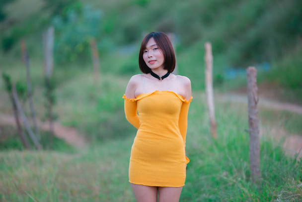 Portrait of beautiful asian woman wear yellow dress at the field,Thailand people - Fotó, kép