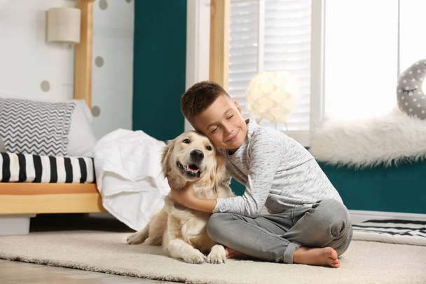 Little boy with his dog in stylish bedroom interior - Fotografie, Obrázek