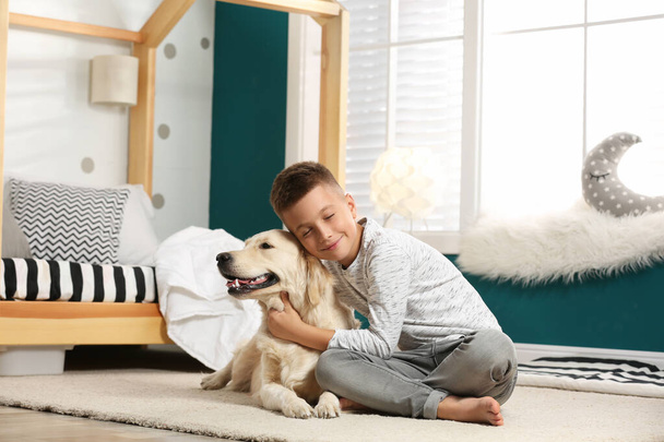 Little boy with his dog in stylish bedroom interior - Valokuva, kuva