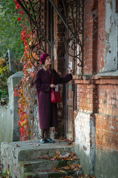 Une femme avec une lettre frappe à la porte d'une vieille maison
. - Photo, image