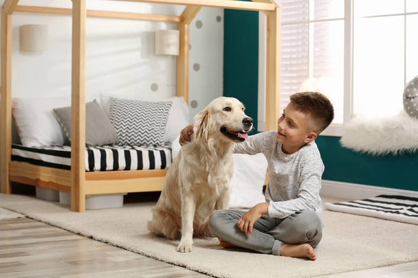 Little boy with his dog in stylish bedroom interior - Фото, изображение