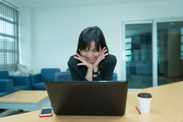 Бізнес-леді вау з ноутбука, Дивлячись фондовий ринок, Щаслива тайська жінка концепція, Секретар працює в офісі
 - Фото, зображення