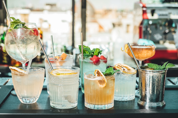 Διαφορετικά αλκοολούχα κοκτέιλ στο τραπέζι του μπαρ, καλοκαιρινά κοκτέιλ από μπάρμαν - Φωτογραφία, εικόνα