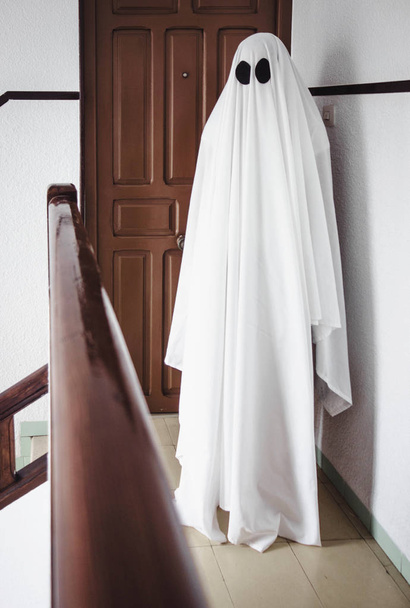Привид вкритий білою плямою привидів на сходах покинутої психіатричної лікарні. Хеллоуїн концепція
 - Фото, зображення