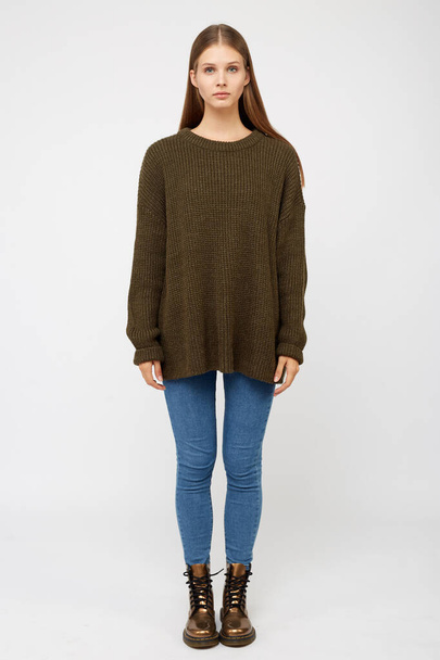Girl dressed in a khaki sweater and jeans. - Φωτογραφία, εικόνα