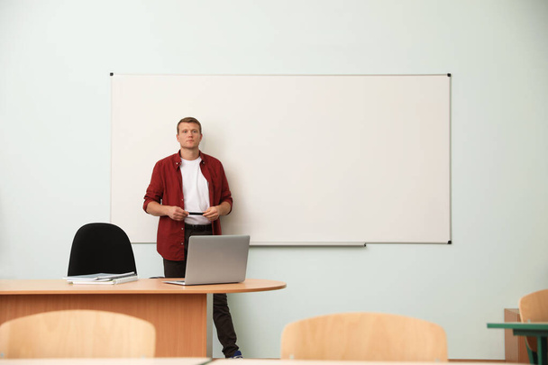 Männlicher Lehrer neben Whiteboard in modernem Klassenzimmer - Foto, Bild