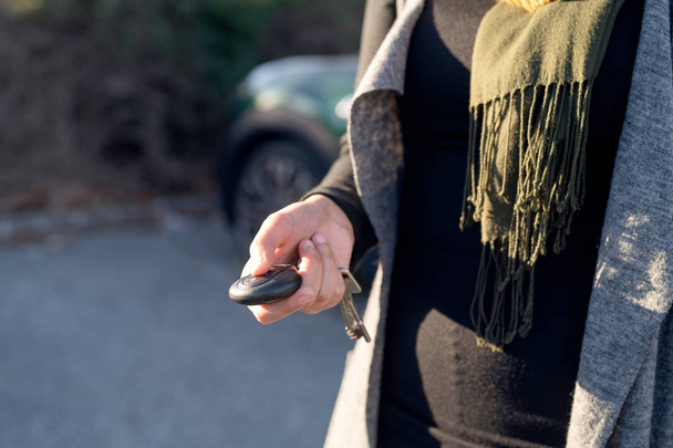 Person's hand unlocking the car with remote control - Photo, Image