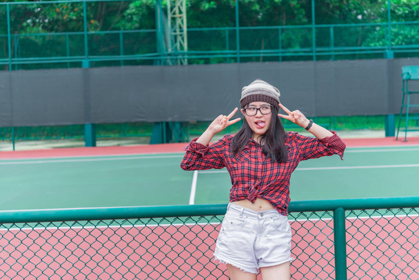 Portrait of asian hipster girl at Tennis Court,Thailand people wear glasses - Foto, imagen