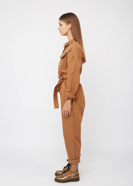 Girl in camel color jumpsuit on white backround. - Foto, immagini