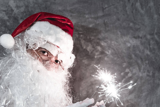 Santa Claus drží ohňostroj pro hru, Veselé Vánoce koncept - Fotografie, Obrázek