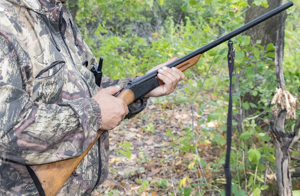 Un hombre con un rifle de caza en sus manos, cargando un arma
. - Foto, imagen