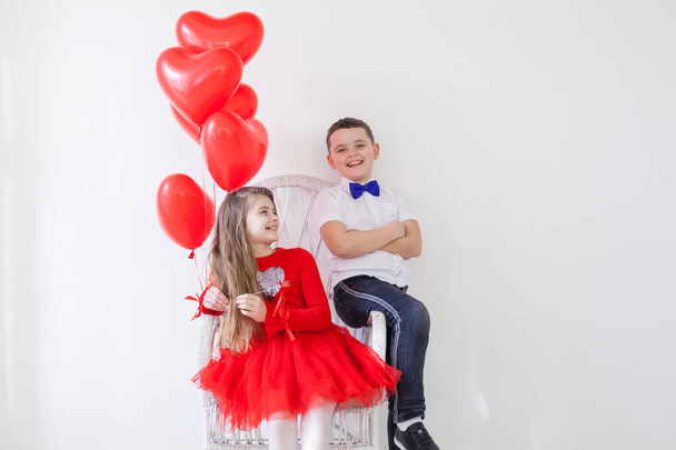 dziewczyna i chłopiec z czerwonymi balonami w kształcie serca - Zdjęcie, obraz