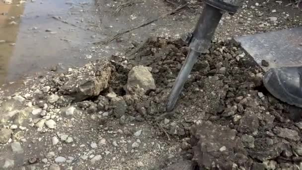 Un uomo lavora con un martello pneumatico. Un martello pneumatico rompe l'asfalto. Strumento di riparazione stradale grande e pesante
 - Filmati, video
