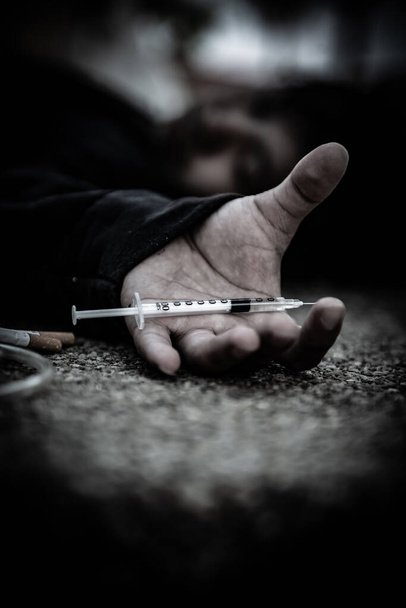 Homem asiático usa capuz negro drogado desesperado, overdose de drogas e o inconsciente chocado, as drogas causam a morte, povo da Tailândia, injetam heroína em vasos sanguíneos
 - Foto, Imagem