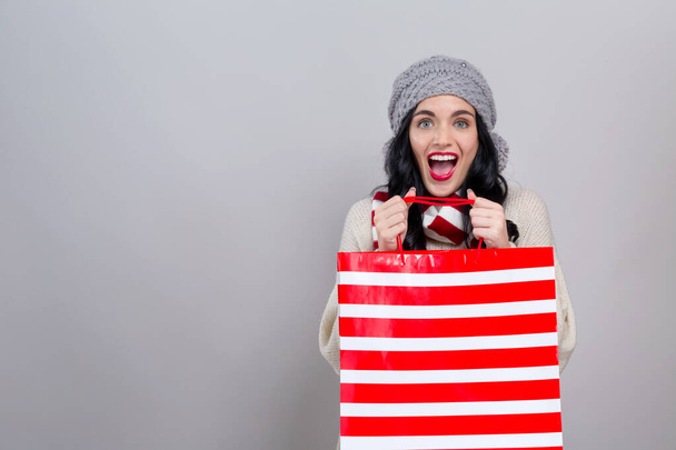 Happy young woman holding a shopping bag - Foto, Imagen