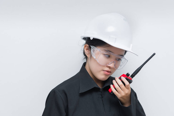 Happy Asian engineer woman wearing glasses,using radio communication on white background,thailand technician use walkie talkie for work - Фото, зображення