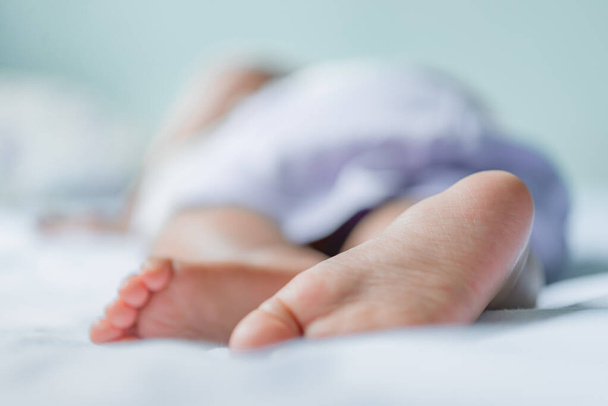 Asian baby sleeping on the bed,thailand people,relax time,Close up feet of baby,selective focus - Foto, afbeelding