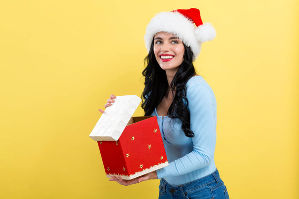 Young woman opening a Christmas gift box - Fotó, kép