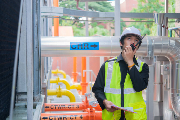 Aziatisch Onderhoud ingenieur bij het afvalwater management systeem van een enorme fabriek, onderhoud controleren van technische gegevens van verwarmingssysteem apparatuur, Thailand mensen - Foto, afbeelding