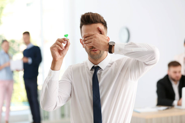 Young businessman playing darts with his eyes closed - Foto, Imagem