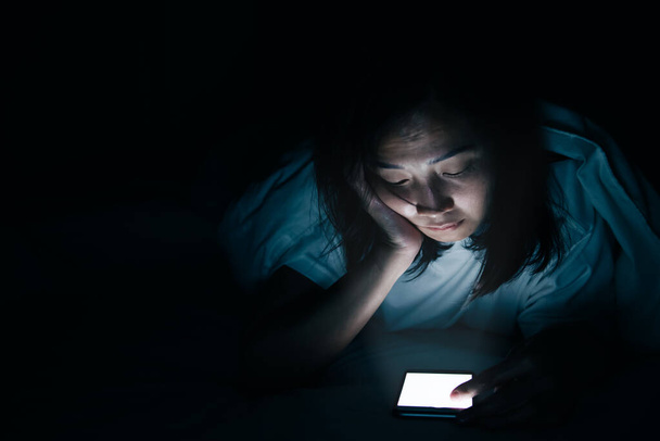 Asian woman playing game on smartphone in the bed at night,Thailand people,Addict social media - Foto, afbeelding