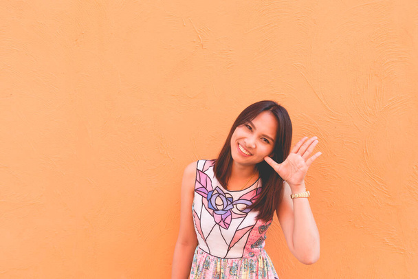 Portrait of beautiful asian woman pose on orange wall,lifestyle of single girl - Valokuva, kuva