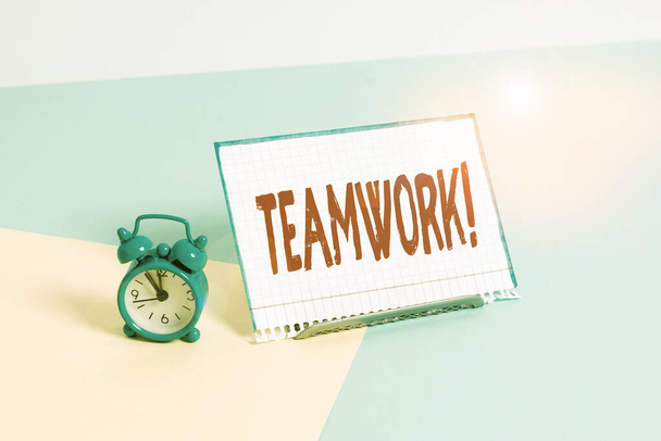 Word writing text Teamwork. Business concept for combined action of group especially when effective and efficient Mini size alarm clock beside a Paper sheet placed tilted on pastel backdrop. - Photo, Image
