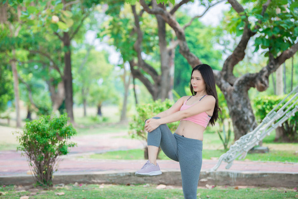Asian sporty woman stretching body breathing fresh air in the park,Thailand people,Fitness and  exercise concept - Valokuva, kuva