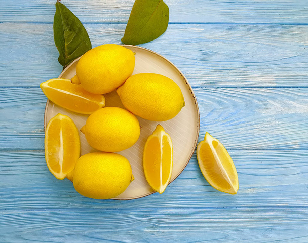 fresh lemon on a plate a wooden background - Foto, afbeelding