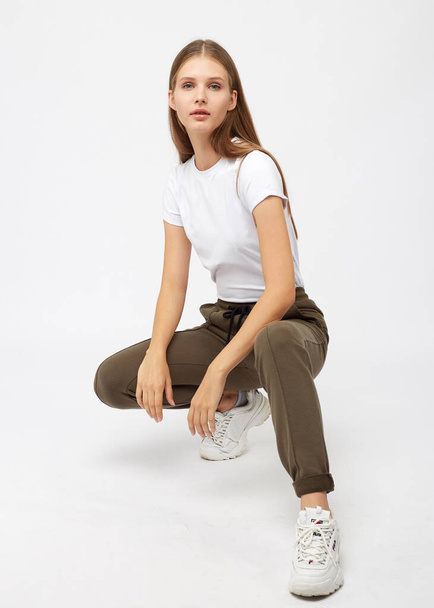 girl in khaki sweatpants and a t-shirt - Foto, afbeelding