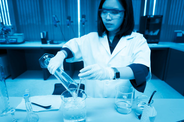 Wissenschaftler injizierte Chemikalien in Plastikröhrchen und mischte Chemikalien mit Schüttelmaschine vor dem Experiment - Foto, Bild