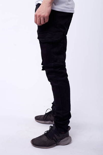 man in jeans, denim pants close up on white background, black jeans. - Фото, зображення
