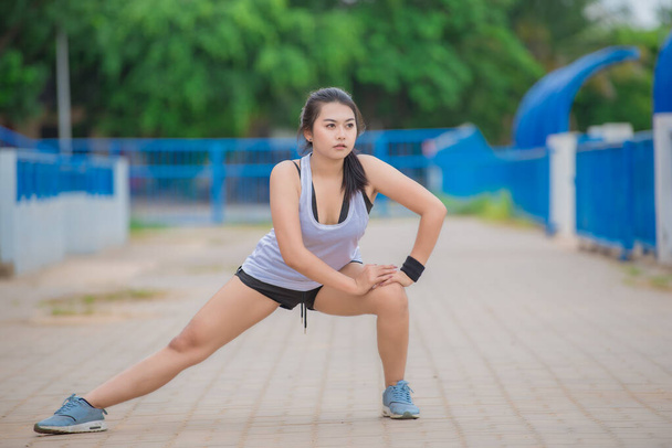 Asian sporty woman stretching body breathing fresh air in the park,Thailand people,Fitness and  exercise concept,Jogging in the track,Fat girls want to thin. - Φωτογραφία, εικόνα