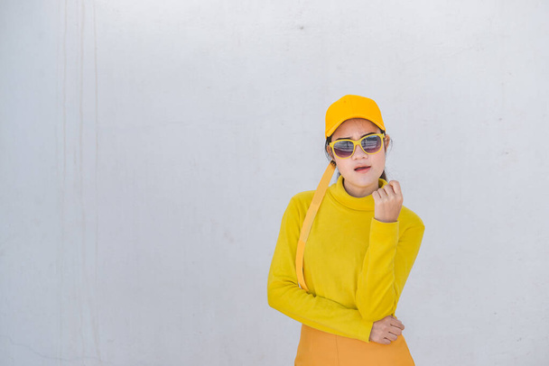 Portrait of beautiful asian woman in yellow cloths on dirty white wall,Hipsters girl wear yellow hat  take a picture,Thailand people - Foto, Imagem