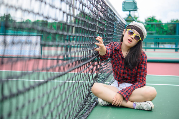 Hipster asian girl pose for take a photo,Fashion portrait pretty woman at tennis court,lifestyle of modern teenage thai girl - Foto, Bild
