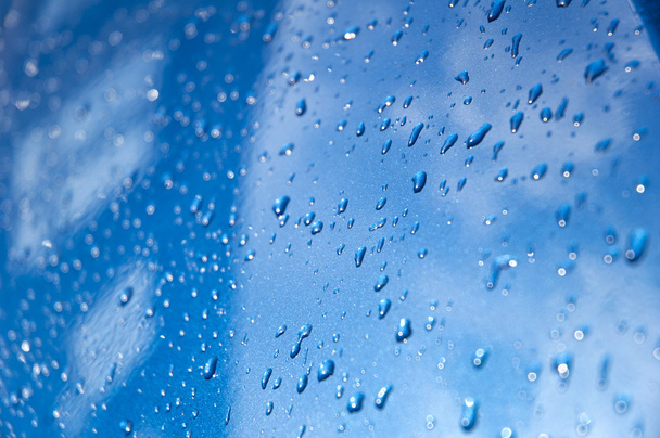 Wassertropfen auf ein blaues Auto - Foto, Bild