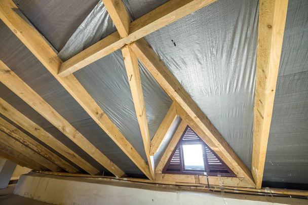 Attic of a building with wooden beams of a roof structure and a  - Photo, Image