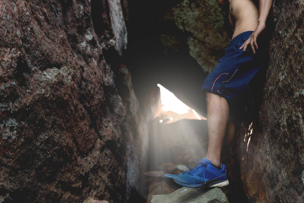Asijský pohledný muž break lezení na jeskyni, on velmi unavený - Fotografie, Obrázek
