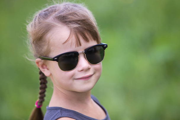 Portrét krásné dítě dívka s copánky ve vlasech venku v su - Fotografie, Obrázek