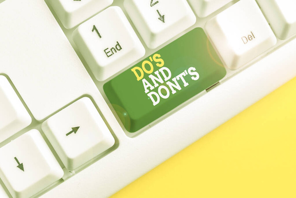 「 Do S 」と「 Don t 」の表記。ビジネス写真いくつかの活動や行動に関する規則や習慣を紹介白い背景の上にノートPCのキーボード. - 写真・画像