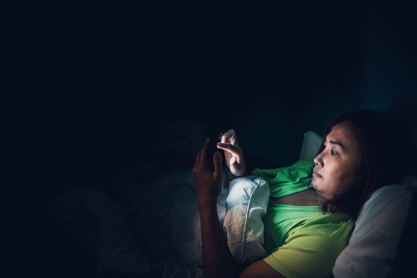 Азійська жінка грає на смартфоні в ліжку вночі, Таїланд люди, Addict соціальні медіа, грати в інтернеті всю ніч - Фото, зображення