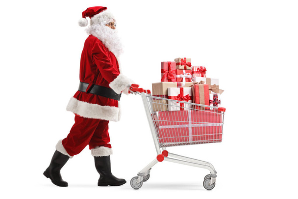 Santa Claus pushing a cart full of presents  - Фото, зображення
