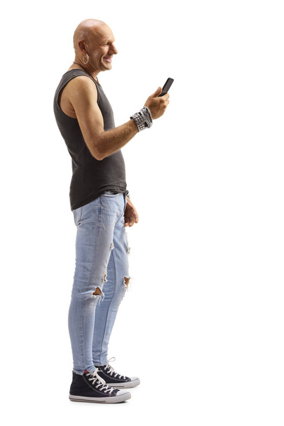 Bald male hipster looking at his mobile phone and smiling - Foto, imagen